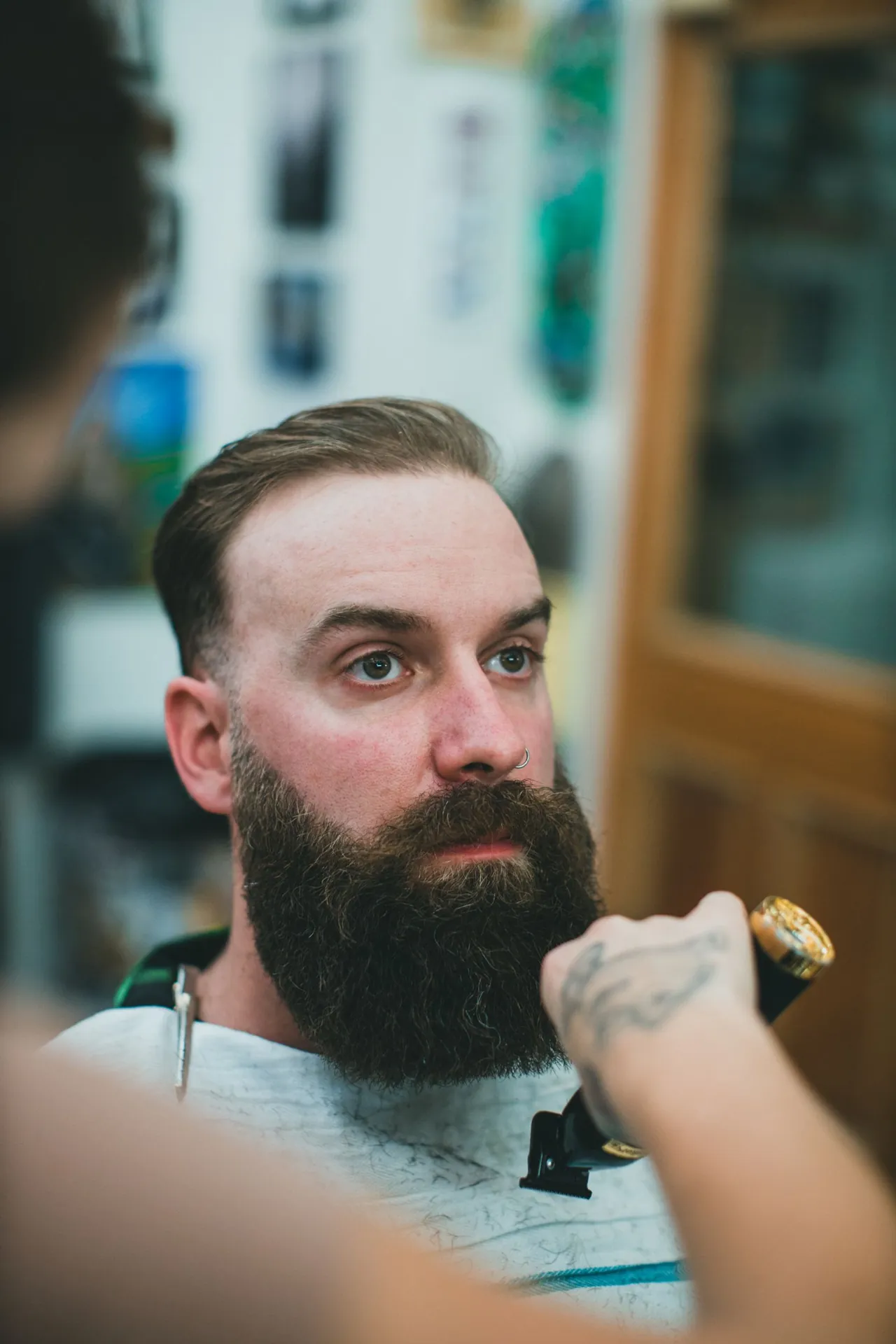 Retrato de un hombre con barba durante un corte de cabello; imagen de ambientación.