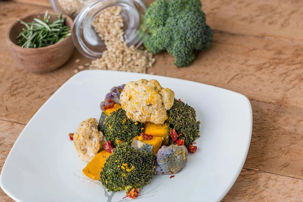 Verduras asadas, brócoli y coliflor sobre un plato blanco.