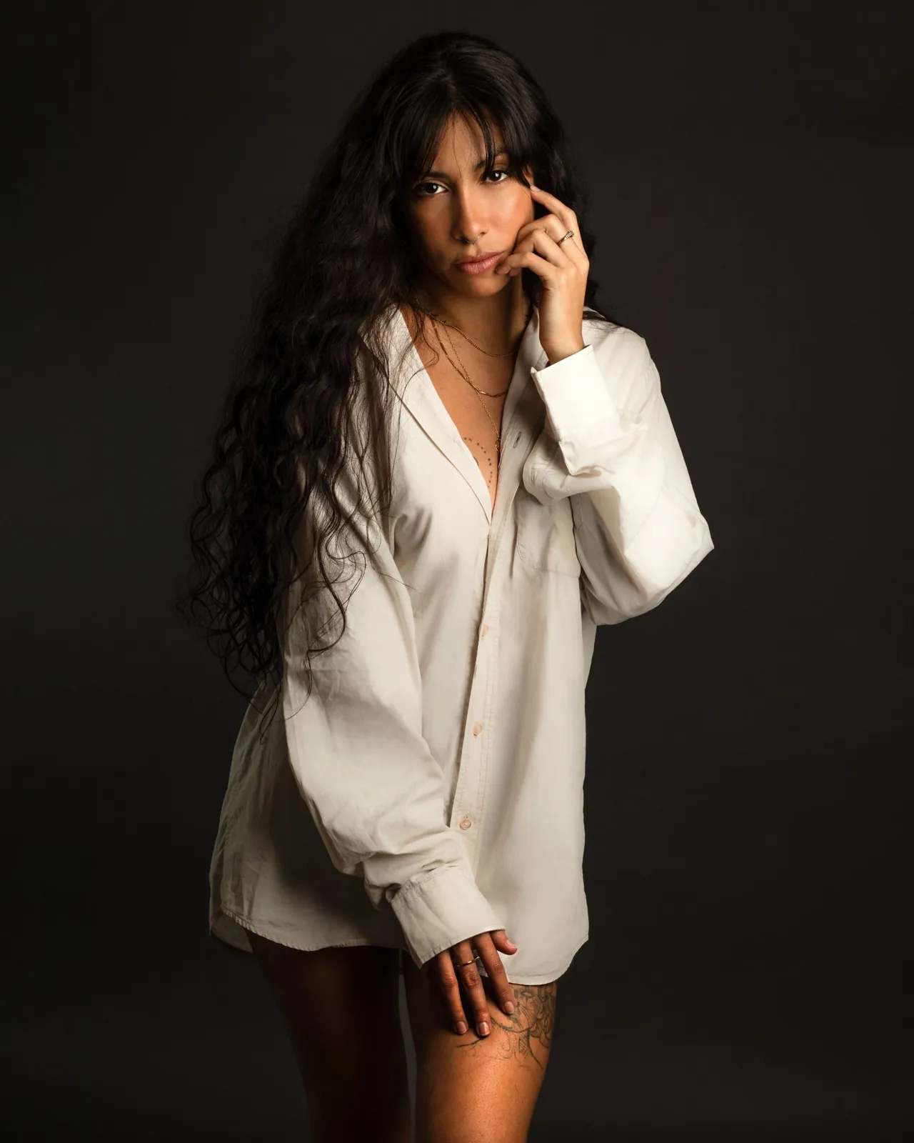 Retrato de estudio de una mujer con cabello largo y oscuro, vestida de blanco.